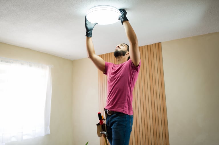Electrician working on ceiling light installation in a modern home